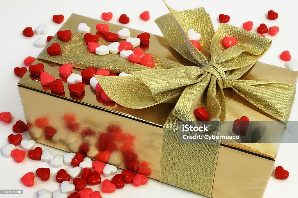 Regalo avvolto con caramelle a forma di cuore circondato - Foto stock royalty-free di Amicizia