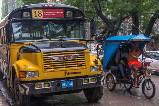 Havana, Cuba - January 15, 2016: Buses and tricycles circulating through the streets of the urban center of the city