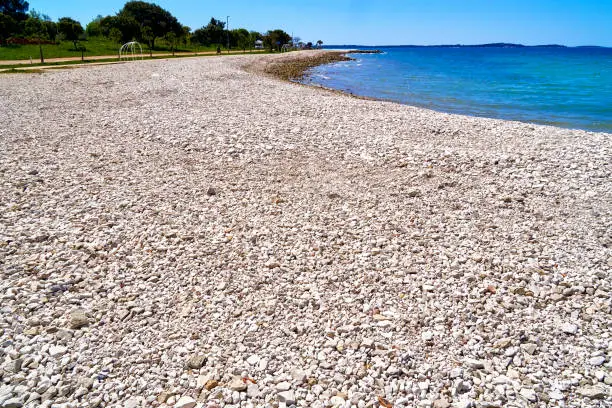 Photo of Large empty beach with gravel on the blue sea on the coast of Istria, Croatia