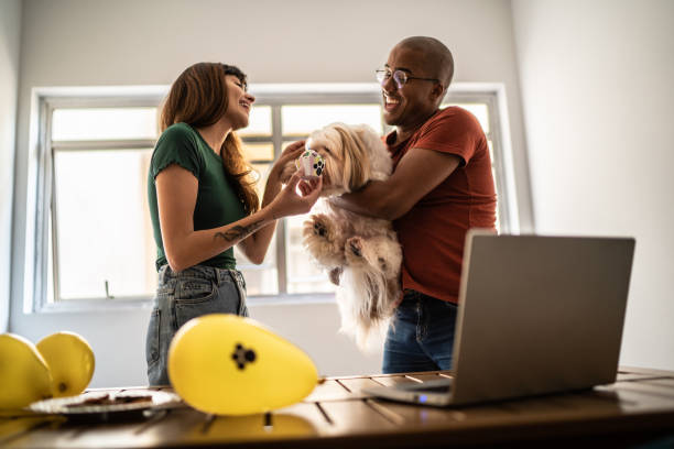 istock Couple celebrating dog's birthday doing a virtual party using laptop at home 1397371108