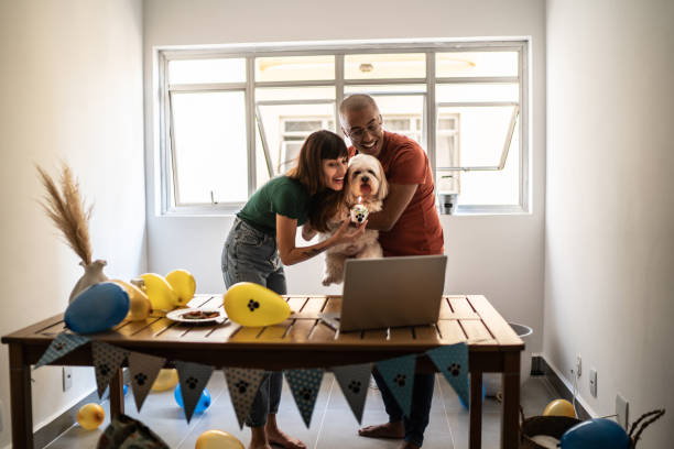 istock Couple celebrating dog's birthday doing a virtual party using laptop at home 1397371122