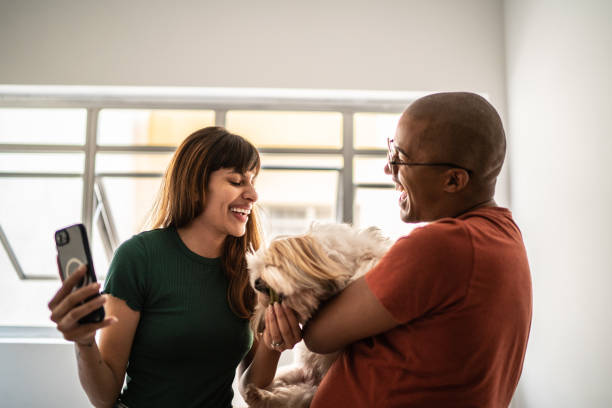 istock Young couple having fun with dog at home 1397371123