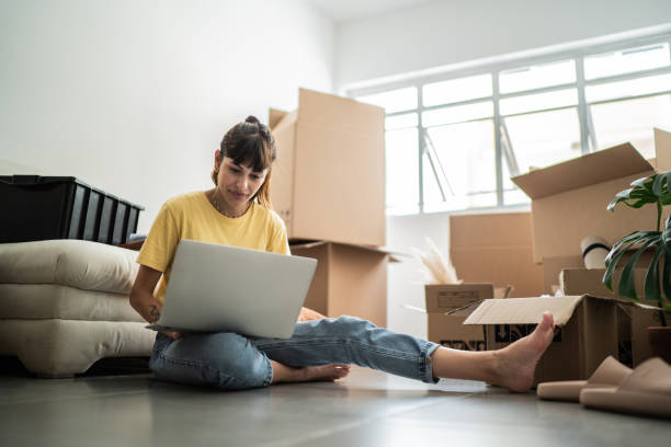 istock Young woman using laptop at new house 1397371381
