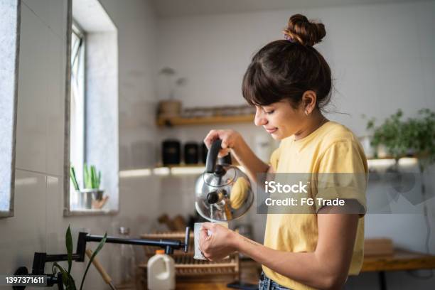 Young Woman Preparing A Tea At Home Stock Photo - Download Image Now - Tea - Hot Drink, Preparation, Making