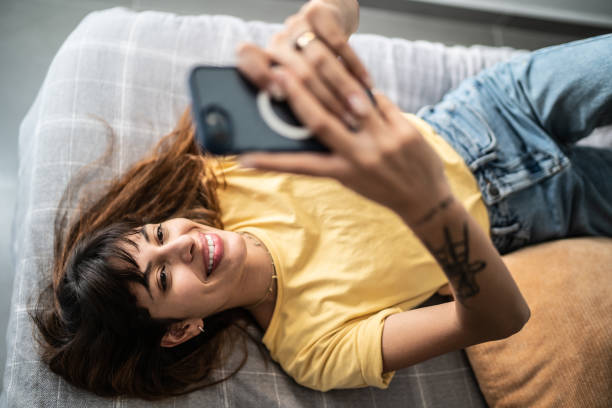 istock Young woman using the mobile phone in the bed at home 1397372238