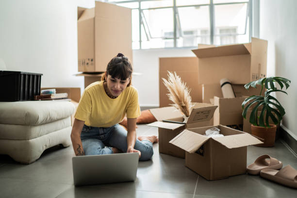 istock Young woman using laptop at new home 1397373064