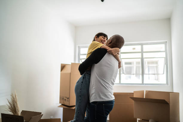 istock Happy young couple moving house, packing moving boxes 1397373115