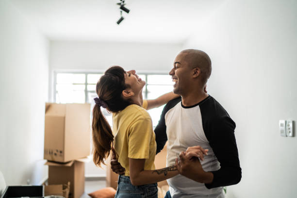 feliz pareja joven bailando al mudarse de casa - couple healthy lifestyle real people characters fotografías e imágenes de stock