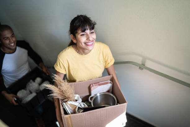 istock Happy couple carrying boxes and moving up stairs 1397373350