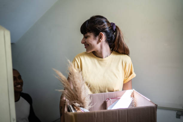 istock Happy couple carrying boxes and moving up stairs 1397373398