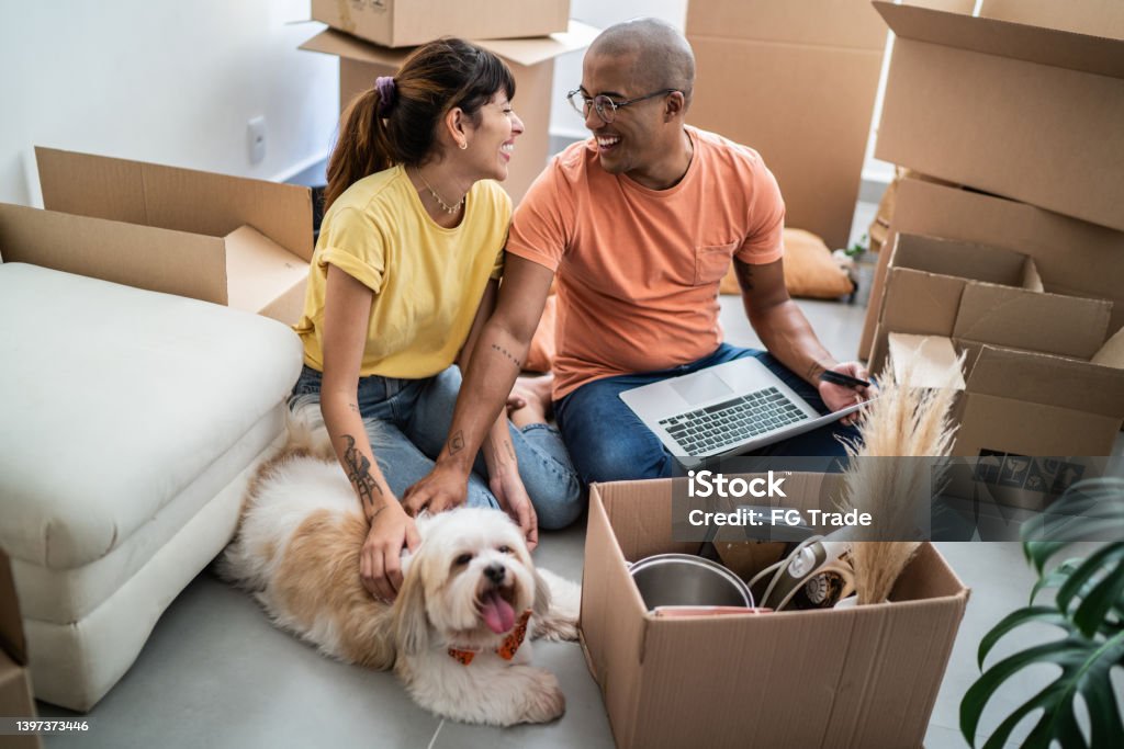 Young couple packing and moving boxes at home Relocation Stock Photo