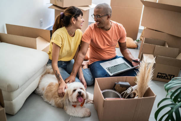 Young couple packing and moving boxes at home Young couple packing and moving boxes at home fresh start stock pictures, royalty-free photos & images