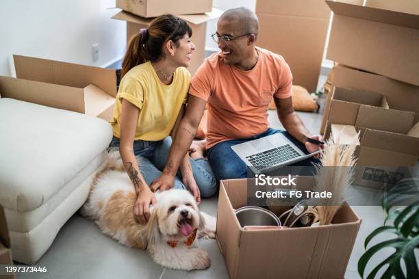 Young Couple Packing And Moving Boxes At Home Stock Photo - Download Image Now - Relocation, Home Ownership, Moving House