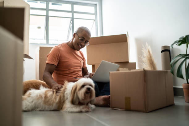 istock Young man using laptop, enjoying dog and moving house 1397373564