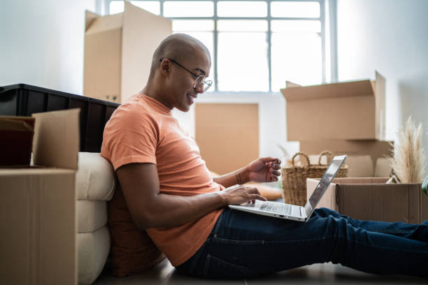 istock Young man doing online shopping using laptop at new home 1397373571