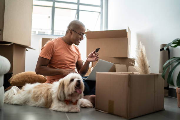 istock Young man doing online shopping using laptop at new home 1397373575
