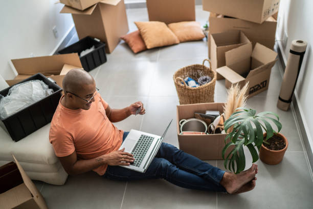 istock Young man doing online shopping using laptop at new home 1397373642