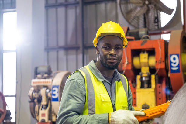 istock African men mechanical engineer, wearing safety equipment. While doing machine maintenance and safety control while work inside of factory area. With blurred background of heavy machine. 1397374481
