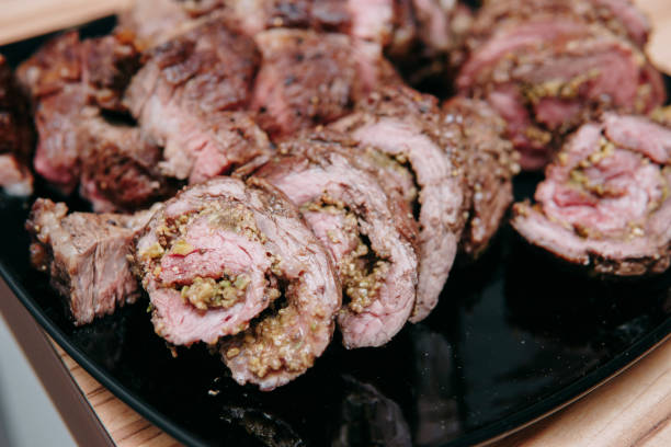 kochen von ribeye-steaks und fleischbrötchen im kochkurs. geschnittenes fleisch auf einem teller, nahaufnahme. - animal bone chop close up color image stock-fotos und bilder
