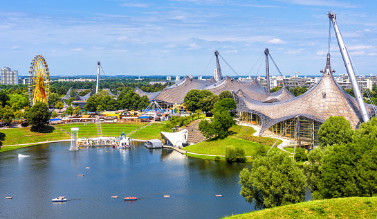 Olympic Park in summer, Munich, Germany, Europe. This place is landmark of Munich. Panorama of green Olympiapark, urban landscape. Scenic view of Munich amusement district, skyline of Munchen city.