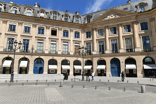 Paris, France-05 11 2022: Two people passing in front of a luxury jewelry store on Place Vendôme in Paris, France.