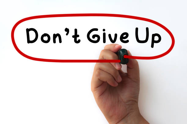 istock Hand writing circling Don't give up text on transparent wipe board. 1397384353