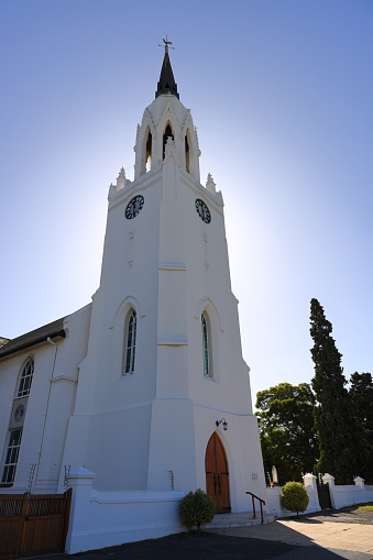 A church steeple in Worcester, South Africa, photographed against clear skies with the sun behind the steeple.