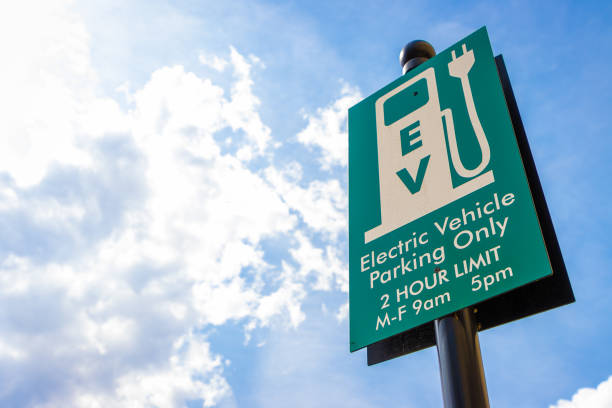 Sign for electric vehicle parking against sunny sky stock photo