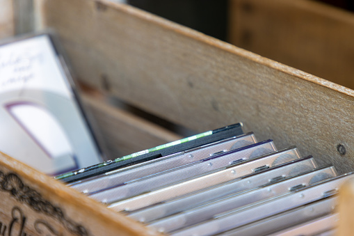 A set of music compact discs (CDs) for sale in a wooden box.