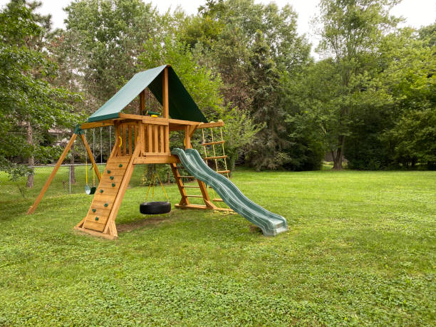 wood backyard playset with wave slide, clubhouses, rock climbing wall, swings with tire swing, an access ladder - 遊樂場 圖片 個照片及圖片檔