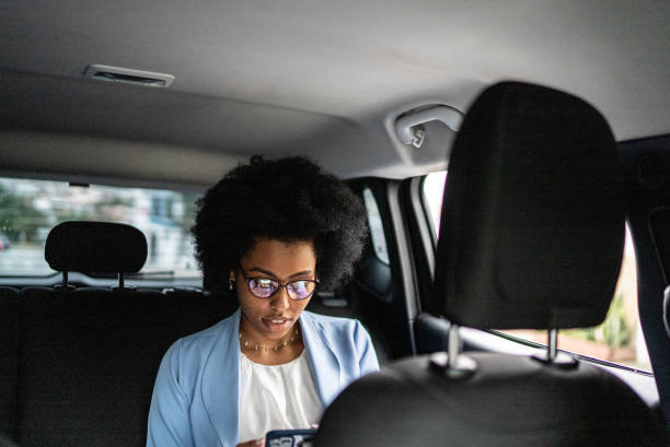 istock Businesswoman using smartphone in a cab 1397393220