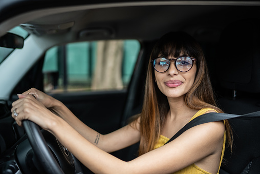 Portrait of a young woman driving a car