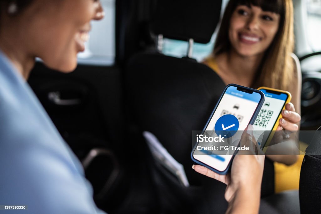 Woman paying a cab driver using contactless payment on smartphone QR Code Stock Photo