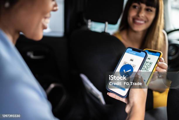 Woman Paying A Cab Driver Using Contactless Payment On Smartphone Stock Photo - Download Image Now