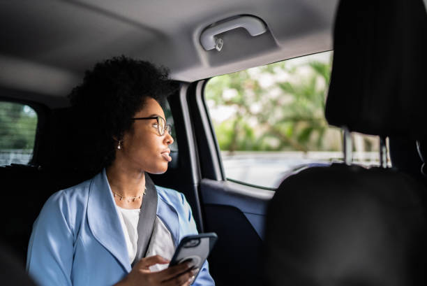 istock Businesswoman using smartphone and looking though the window in a cab 1397393343