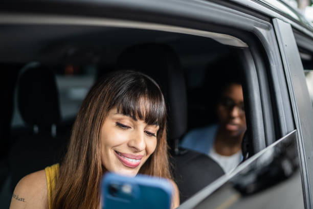 istock Cab driver talking to passenger and show her the smartphone 1397394266