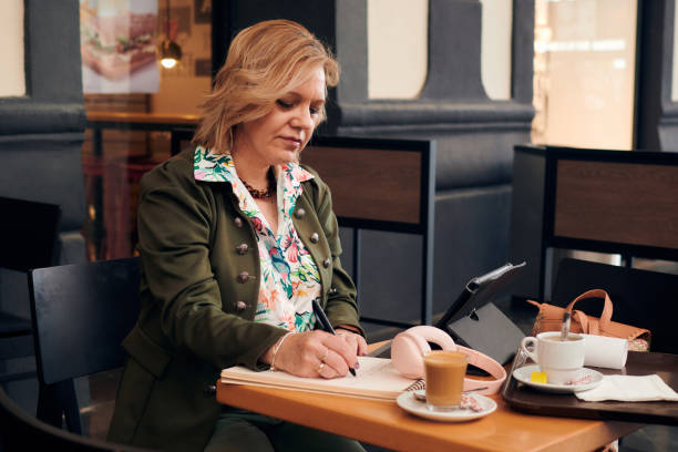 istock Businesswoman working from coffee shop with a tablet and a notebook 1397394317