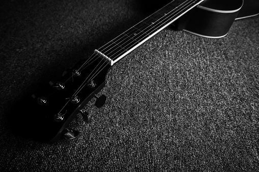 Acoustic guitar on carpet in black and white
