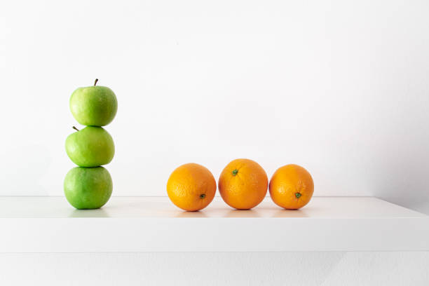 istock Green apples and oranges on a white background close-up. 1397402143