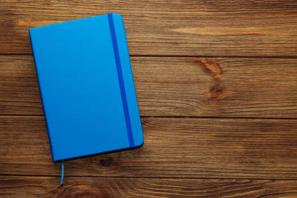 istock Blue notepad diary lies on a wooden table, management concept 1397404738