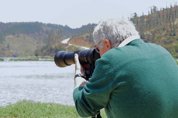 istock man focusing his telephoto lens while taking a picture 1397405555