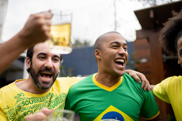 des amis célèbrent la victoire de l’équipe de football brésilienne - barbecue foot photos et images de collection