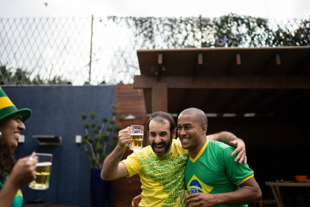 des amis célèbrent la victoire de l’équipe de football brésilienne - barbecue foot photos et images de collection