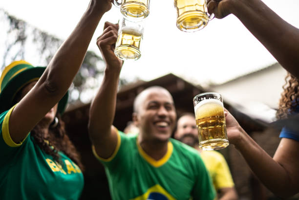 des amis trinquent pour célébrer la victoire de l’équipe de football brésilienne - barbecue foot photos et images de collection