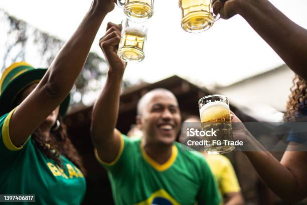 Friends toasting to celebrate Brazilian soccer team winning