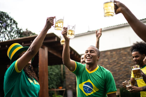 des amis trinquent pour célébrer la victoire de l’équipe de football brésilienne - barbecue foot photos et images de collection