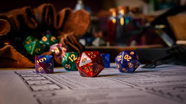 Red d20 on a character sheet Close up of spilling out dice of different kinds from a dice bag on a character sheet. developing 8 stock pictures, royalty-free photos & images