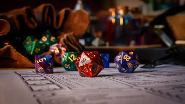 Close up of spilling out dice of different kinds from a dice bag on a character sheet.