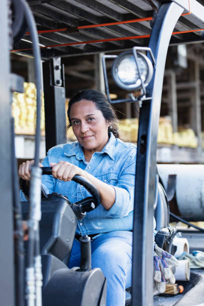 istock Mature Hispanic woman driving forklift at lumberyard 1397409321