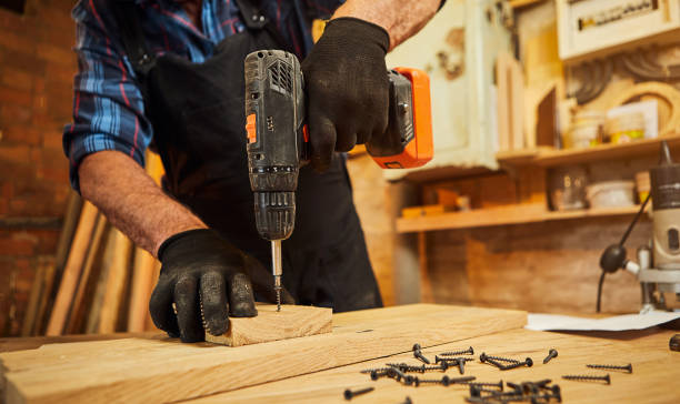 istock Senior carpenter with drilling instrument working in the carpentry workshop to make a piece of furniture 1397409364